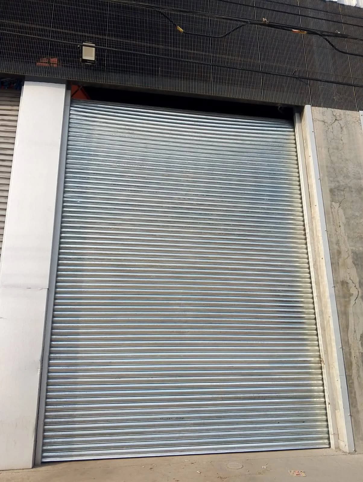 Cortina de acero galvanizada sin pintar en el acceso alto de una bodega