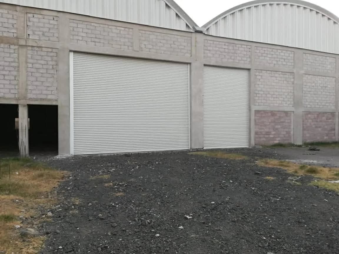 Dos cortinas de acero blancas instaladas en la fachada de una nave industrial